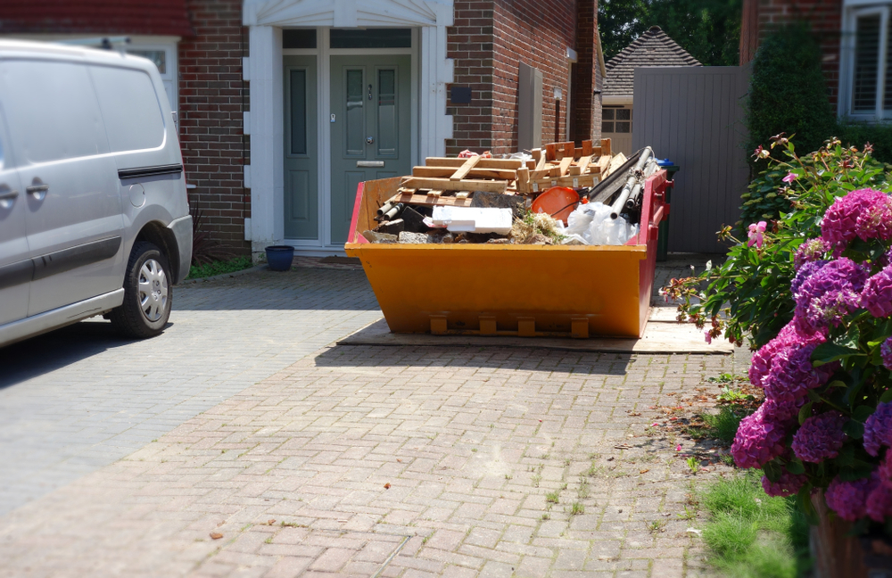 Skip hire - a skip on a driveway filled with waste
