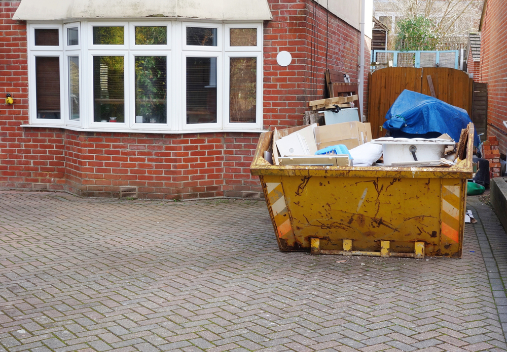 Skip hire Solihull - skip on a driveway filled with domestic waste during a home renovation project.